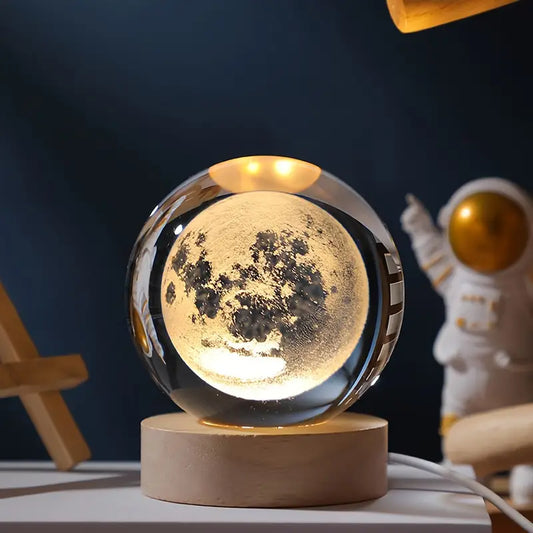 "Crystal ball with moon phase design glowing on dark stand"